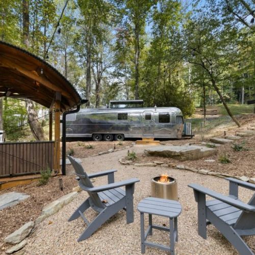 Private outdoor area with adirondack chairs, solo stove fire pit, & covered deck.