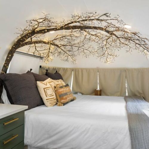 King bed with tree light fixture.